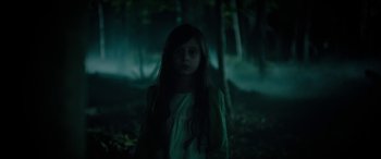 Movie still from “Wildling” (2018), directed by Fritz Böhm – A young girl standing in the woods at night; Medium shot, Low angle