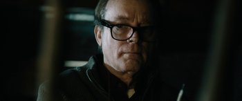 Movie still from “Wildling” (2018), directed by Fritz Böhm – An older man wearing glasses and a jacket; Close Up shot, Low angle