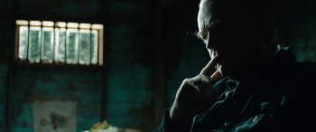 Movie still from “Wildling” (2018), directed by Fritz Böhm – A man sitting in front of a window in a dark room; Close Up shot, Over the shoulder angle