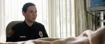 Movie still from “Wildling” (2018), directed by Fritz Böhm – A police officer sitting in front of a window; Close Up shot, Over the shoulder angle