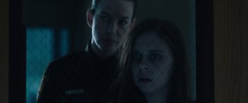 Movie still from “Wildling” (2018), directed by Fritz Böhm – A man and a woman standing next to each other in front of a fence; Close Up shot, Over the shoulder angle