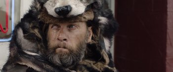 Movie still from “Wildling” (2018), directed by Fritz Böhm – A person wearing a bear hat; Close Up shot, Over the shoulder angle
