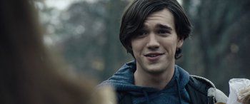 Movie still from “Wildling” (2018), directed by Fritz Böhm – A man with long hair and a blue hoodie; Close Up shot, Over the shoulder angle