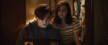 Movie still from “Wildling” (2018), directed by Fritz Böhm – A man and a woman looking at a laptop screen; Medium shot, Over the shoulder angle