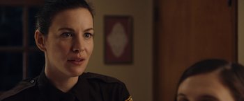 Movie still from “Wildling” (2018), directed by Fritz Böhm – A woman wearing a uniform is looking at the camera; Close Up shot, Over the shoulder angle