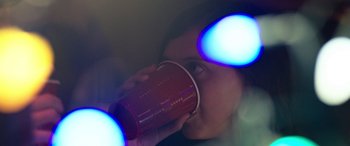 Movie still from “Wildling” (2018), directed by Fritz Böhm – A woman drinking from a red coffee cup; Extreme Close Up shot, Over the shoulder angle