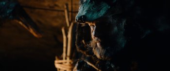 Movie still from “Wildling” (2018), directed by Fritz Böhm – A man with long hair and a beard wearing a bear costume; Close Up shot, Over the shoulder angle
