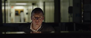 Movie still from “Wildling” (2018), directed by Fritz Böhm – A man sitting in front of a computer monitor; Close Up shot, Low angle