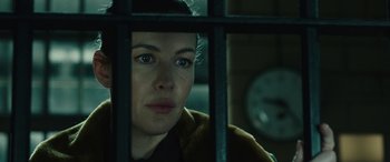 Movie still from “Wildling” (2018), directed by Fritz Böhm – A woman looking through the bars of a jail cell; Close Up shot, Low angle
