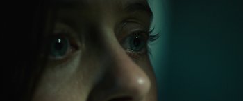 Movie still from “Wildling” (2018), directed by Fritz Böhm – A person's eyes with a blue tint; Extreme Close Up shot, High angle
