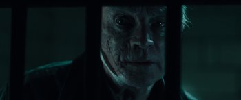 Movie still from “Wildling” (2018), directed by Fritz Böhm – An old man with a creepy look on his face; Close Up shot, Low angle