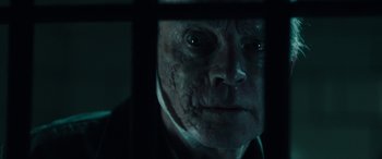 Movie still from “Wildling” (2018), directed by Fritz Böhm – An old man with a scar on his face looking through a window; Close Up shot, Low angle