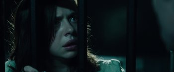 Movie still from “Wildling” (2018), directed by Fritz Böhm – A young woman looking out of a window at night; Close Up shot, Low angle