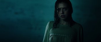 Movie still from “Wildling” (2018), directed by Fritz Böhm – A woman in a green dress standing in the dark; Close Up shot, Low angle