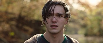 Movie still from “Wildling” (2018), directed by Fritz Böhm – A young man with wet hair looking at the camera; Close Up shot, Over the shoulder angle