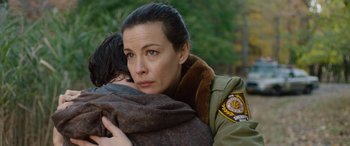 Movie still from “Wildling” (2018), directed by Fritz Böhm – A woman holding a child in her arms and wearing a uniform; Close Up shot, Over the shoulder angle