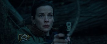 Movie still from “Wildling” (2018), directed by Fritz Böhm – A woman is holding a gun in a dark place; Close Up shot, High angle