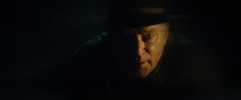 Movie still from “Wildling” (2018), directed by Fritz Böhm – A person wearing a hat in the dark; Close Up shot, Low angle