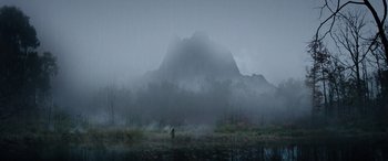 Movie still from “Wildling” (2018), directed by Fritz Böhm – A person standing in the middle of a field in front of a mountain; Extreme Wide shot, High angle