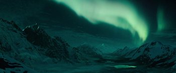 Movie still from “Wildling” (2018), directed by Fritz Böhm – A view of a mountain range with a green sky in the background; Extreme Wide shot, Low angle