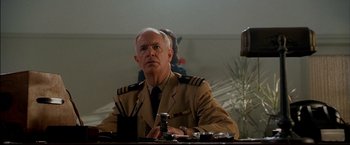 Movie still from “Windtalkers” (2002), directed by John Woo – An older man in a military uniform sitting at a table; Close Up shot, Low angle