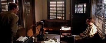 Movie still from “Windtalkers” (2002), directed by John Woo – A living room with a wooden bench and a window; Wide shot, High angle