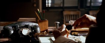 Movie still from “Windtalkers” (2002), directed by John Woo – A person sitting at a table with a pen and a pencil; Extreme Close Up shot, High angle
