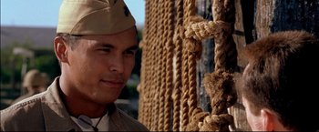 Movie still from “Windtalkers” (2002), directed by John Woo – A man in a military uniform standing next to a rope wall; Close Up shot, Low angle