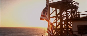 Movie still from “Windtalkers” (2002), directed by John Woo – Two american flags are hanging on the side of a pier; Wide shot, Low angle