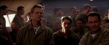 Movie still from “Windtalkers” (2002), directed by John Woo – A group of men standing next to each other in a room; Medium shot, Low angle