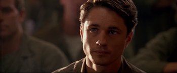 Movie still from “Windtalkers” (2002), directed by John Woo – A man's face in a dimly - lit room; Close Up shot, Over the shoulder angle