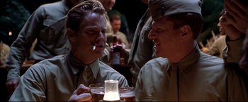Movie still from “Windtalkers” (2002), directed by John Woo – A couple of men sitting next to each other at a table; Medium shot, Over the shoulder angle