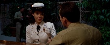 Movie still from “Windtalkers” (2002), directed by John Woo – A woman in a uniform holding a glass of beer; Close Up shot, Over the shoulder angle