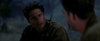Movie still from “Windtalkers” (2002), directed by John Woo – A person sitting in front of another person; Close Up shot, Over the shoulder angle