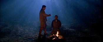 Movie still from “Windtalkers” (2002), directed by John Woo – Two men standing next to each other around a fire; Wide shot, High angle