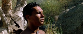 Movie still from “Windtalkers” (2002), directed by John Woo – A man with a necklace is standing in the grass; Close Up shot, Low angle