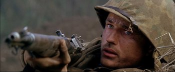Movie still from “Windtalkers” (2002), directed by John Woo – A man holding a rifle while wearing a hat; Close Up shot, High angle
