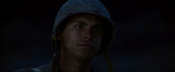 Movie still from “Windtalkers” (2002), directed by John Woo – A man wearing a military helmet with a dark background; Close Up shot, Low angle