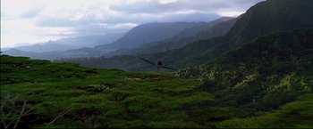 Movie still from “Windtalkers” (2002), directed by John Woo – An airplane is flying over a lush green hillside; Extreme Wide shot, Low angle