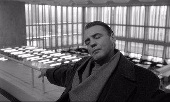 Movie still from “Wings of Desire” (1987), directed by Wim Wenders – A black and white photo of a man with his eyes closed; Medium shot, Low angle