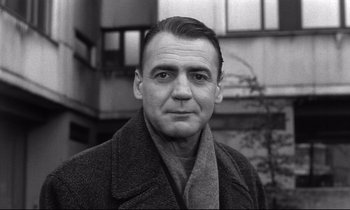 Movie still from “Wings of Desire” (1987), directed by Wim Wenders – An older man wearing a coat and a scarf; Close Up shot, Low angle