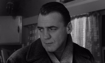 Movie still from “Wings of Desire” (1987), directed by Wim Wenders – Black and white photograph of a man in a coat; Close Up shot, Low angle