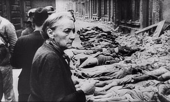 Movie still from “Wings of Desire” (1987), directed by Wim Wenders – An old woman standing in front of a group of dead bodies; Medium shot, Over the shoulder angle