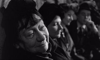 Movie still from “Wings of Desire” (1987), directed by Wim Wenders – A woman sitting next to another woman in front of a wall; Close Up shot, Over the shoulder angle