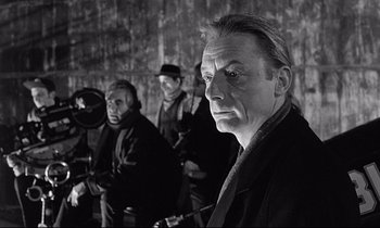 Movie still from “Wings of Desire” (1987), directed by Wim Wenders – A black and white photo of a group of people; Close Up shot, Over the shoulder angle