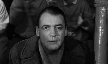 Movie still from “Wings of Desire” (1987), directed by Wim Wenders – Black and white photograph of a man in a crowd; Close Up shot, Low angle