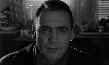 Movie still from “Wings of Desire” (1987), directed by Wim Wenders – Black and white photograph of a man's face in front of a window; Close Up shot, Low angle