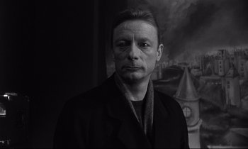 Movie still from “Wings of Desire” (1987), directed by Wim Wenders – Black and white photograph of a man in front of a painting; Close Up shot, Low angle