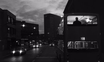 Movie still from “Wings of Desire” (1987), directed by Wim Wenders – A black and white photo of a bus on a street; Wide shot, Low angle