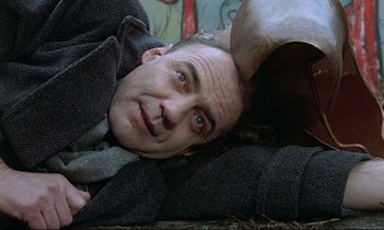 Movie still from “Wings of Desire” (1987), directed by Wim Wenders – A man laying on the ground with his head upside down; Close Up shot, Low angle
